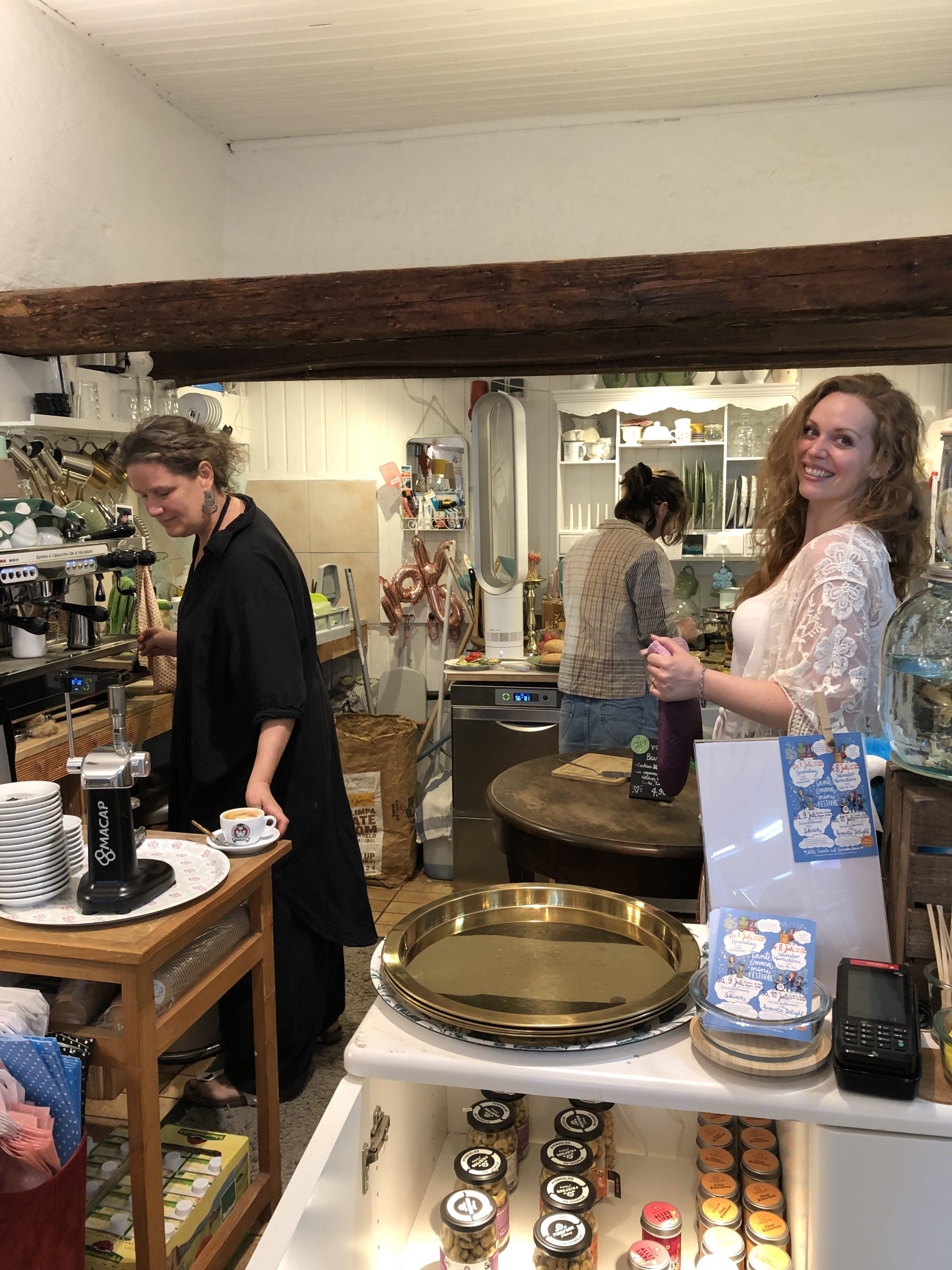 Drei Frauen stehen in der Kochecke und bereiten Kaffee und Essen zu